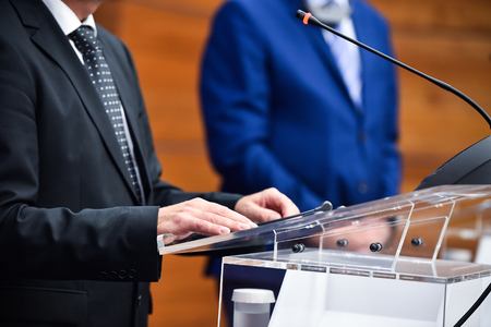 Detail shot with man in suits during a press conferenceの写真素材
