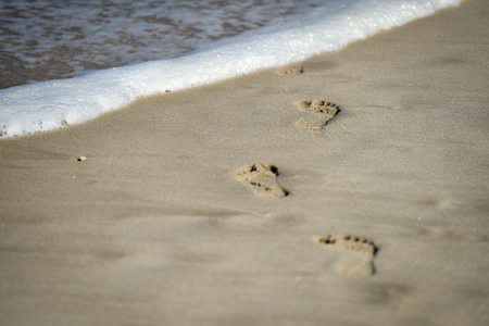 Detail shot with man footprints in the sand on a beachの写真素材