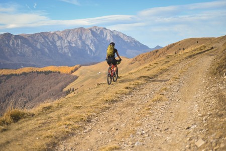 Autumn mountain scene riding with a mountain bike equipped with travel bagsの写真素材