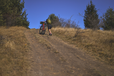 Autumn mountain scene riding with a mountain bike equipped with travel bagsの写真素材