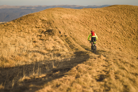 Autumn mountain scene riding with a mountain bike equipped with travel bagsの写真素材