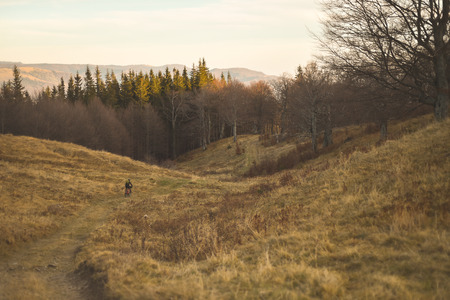 Autumn mountain scene riding with a mountain bike equipped with travel bagsの写真素材