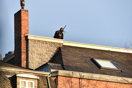 Special forces sniper securing a perimeter from a rooftopの写真素材
