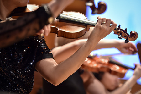 Violin players hand detail during philharmonic orchestra performanceの写真素材