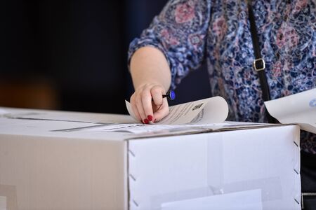 Hand of a person casting a vote into the ballot box during electionsの写真素材