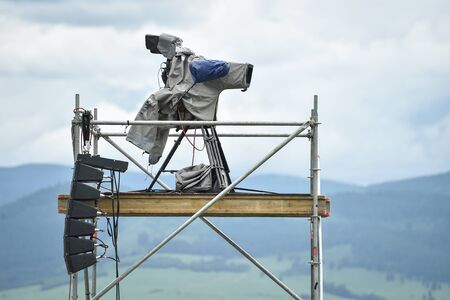 Television broadcast camera setup on a tripod and protected by a rain coverの写真素材