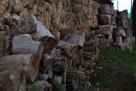 Wooden log slices at a stone wall.の写真素材