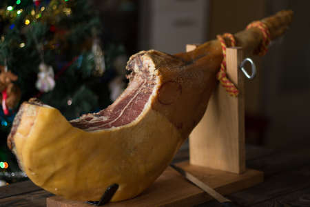 Whole serrano ham on a Christmas tree background.の写真素材