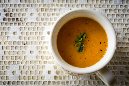 Soup with carrots, ginger and orange juice decorated with mint seen from aboveの写真素材