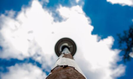 A lantern with rust in the sky and clouds in the background