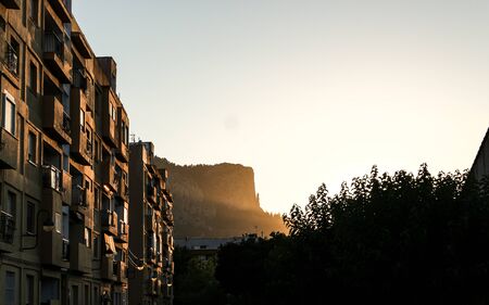 Sunset in a city with mountains in the background and blue skyの写真素材