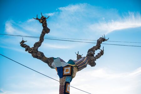 Tree with storm yarn. Sewn with coloured wool, street and creative art.With the blue sky in the backgroundの写真素材