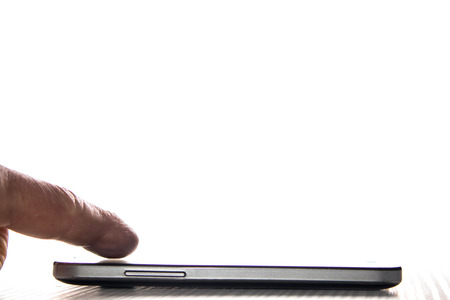 Mobile phone with profile on white background with a finger on the screen. Modern technologyの写真素材