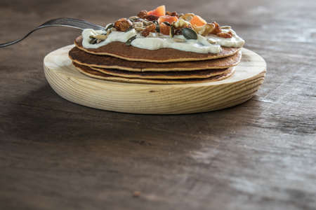 Pancake with cream and nuts. Close-up photo detail. Healthy and delicious breakfastの写真素材