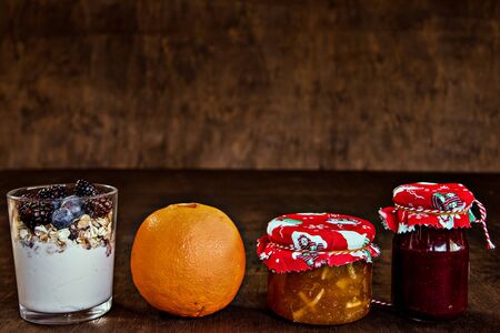 Healthy and delicious food for breakfast. Yogurt with cereals,jam and fruit. Banana and orangeの写真素材