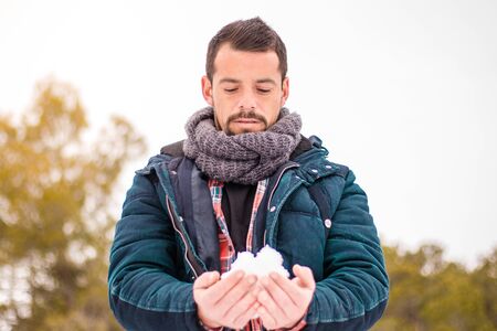 Man playing with the snow. Snowball in the handsの写真素材