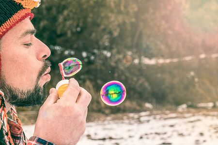 Playing with soap bubbles. Man in a funny hatの写真素材