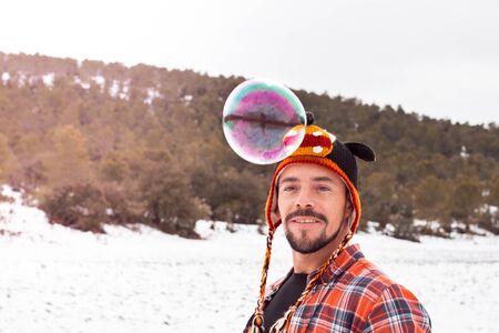 Playing with soap bubbles. Man in a funny hatの写真素材