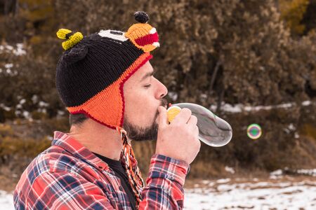 Playing with soap bubbles. Man in a funny hatの写真素材