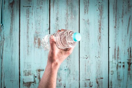 A hand catching a bottle of natural water.の写真素材