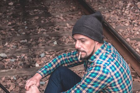 Man dressed casually smoking a cigarette. Bad boy attitude