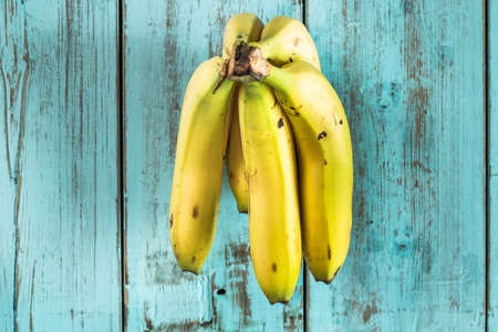Bananas on a rustic blue wooden table. Healthy foodの写真素材