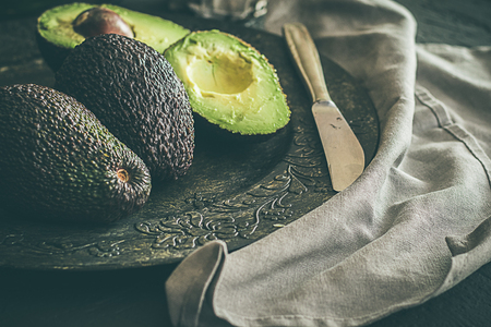 Whole avocados, on dark grey background