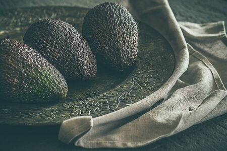 Whole avocados, on dark grey background