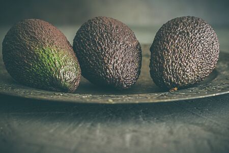 Whole avocados, on dark grey backgroundの写真素材