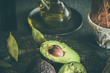 Avocados, bread and olive oil, healthy food on dark backgroundの写真素材