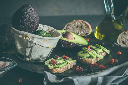 Toast with avocado and oil. Bread with avocado. Concept of healthy food. Dark backgroundの写真素材