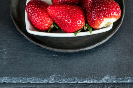 Strawberries on a plate. Grey and rustic backgroundの写真素材