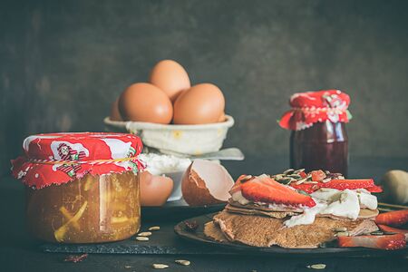 Pancakes for breakfast. With strawberries, yogurt, eggs, flour and jam. Various ingredientsの写真素材