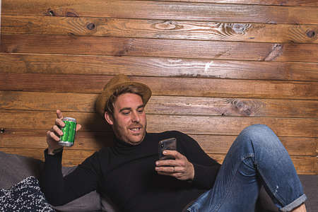 Modern man looking at his cell phone. Relaxed Expressionの写真素材