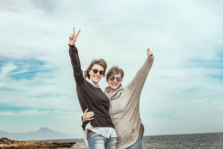 Two girls smiling and having fun on the beach. Concept of friendship. Healthy and cheerful lifestyleの写真素材
