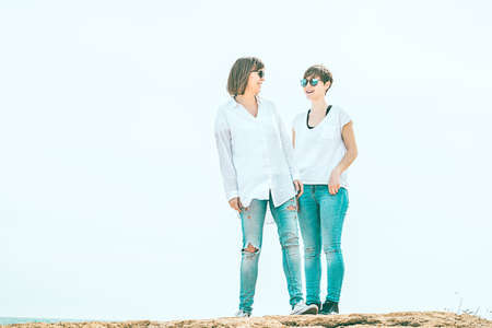 Two women dressed in white looking at each other