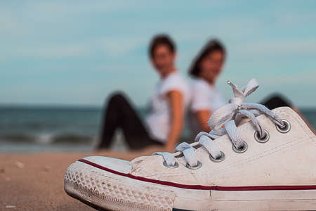 Shoe on the beach and people in the backgroundの写真素材