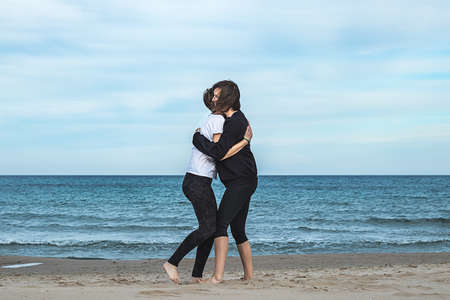 Two girls hugging on the beach. Concept of friendship between two normal girlsの写真素材