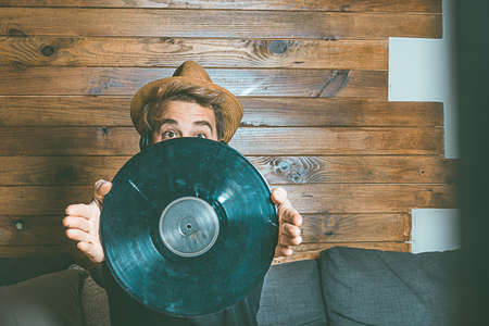 Guy with music helmets and vinyl in his hands. Concept of music, social networking photography