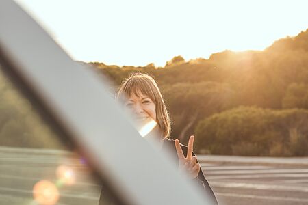 Girl with her fingers up with a positive gesture at sunset .の写真素材