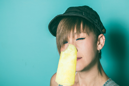 Close-up of a pretty girl eating ice cream. Modern, beautiful woman eating ice creamの写真素材