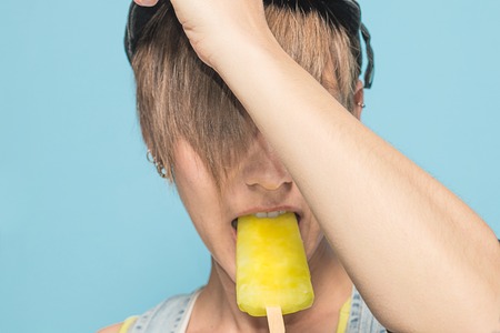 Close-up of a pretty girl eating ice cream. Modern, beautiful woman eating ice creamの写真素材