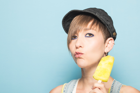 Close-up of a pretty girl eating ice cream. Modern, beautiful woman eating ice creamの写真素材