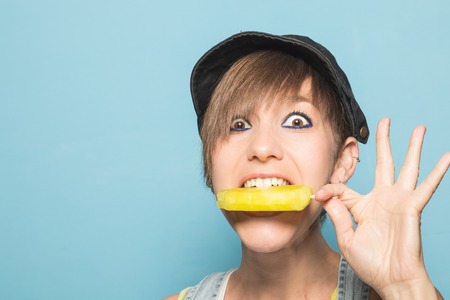Modern girl eating ice cream with a funny expression. Beautiful woman eating ice creamの写真素材