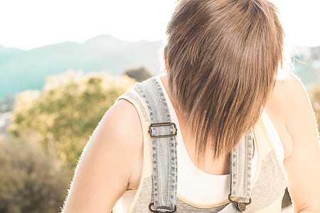 Girl covering her face with her hair. Girl with short, blonde hairの写真素材
