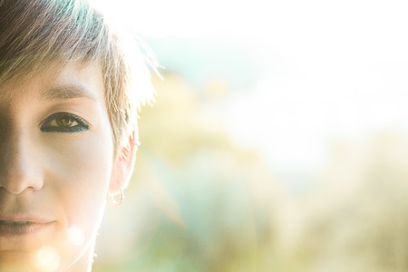 Half-faced portrait of a beautiful woman outdoors. Social network style photographyの写真素材