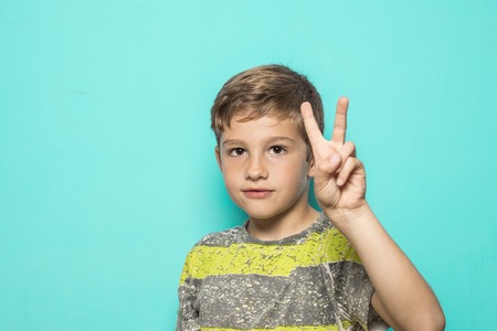 Child making the peace sign with his hand. Sign of peace with the hand