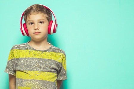 Child listening to music with headphones. Lovely Kid with music helmetsの写真素材