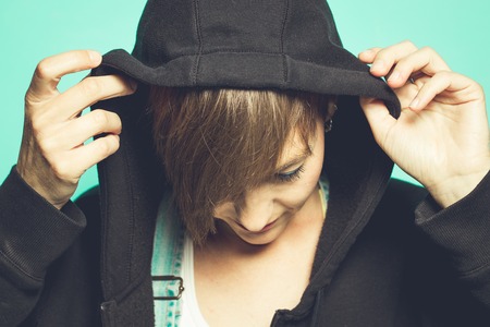 Portrait of a girl in a hood overlooking the floorの写真素材