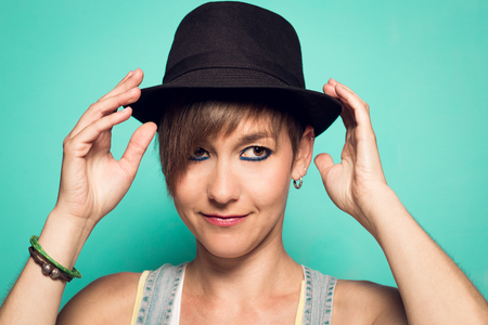 Pretty girl with a hat and a positive attitude. Girl with short hair smilingの写真素材